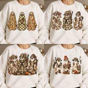 May include: A white sweatshirt featuring four distinct graphic designs of ghosts. The ghosts are depicted with various outdoor and hunting-themed accessories, including camouflage hats, plaid patterns, hunting gear, fishing equipment, and autumn-themed foliage.