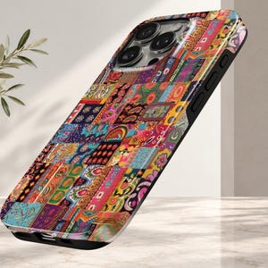 May include: A smartphone case featuring a vibrant, multi-colored patchwork design with intricate floral, paisley, and geometric patterns in shades of red, orange, yellow, blue, and purple. The case has a black frame and a cutout for the camera lens.
