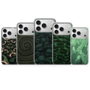 Peut inclure: Cinq coques de téléphone transparentes avec des motifs graphiques distincts alignées. Les designs incluent un motif d'yeux, une spirale sombre, des crânes, une série de lèvres sombres et des petits fantômes vert pâle sur fond vert clair.