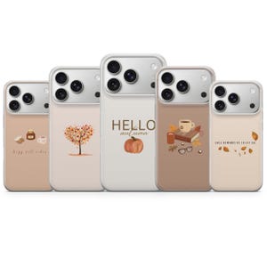 May include: Five clear phone cases featuring autumn-themed designs. The cases display illustrations of a candle, a tree with orange leaves, a pumpkin with the text HELLO autumn, a book with a coffee mug, and falling leaves with the text FALL REMINDS US TO LET GO.