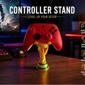 May include: A gold and green trophy-shaped controller stand holding a red gaming controller. The stand features a figure holding up a globe-like top. Text on the image reads: CONTROLLER STAND, LEVEL UP YOUR SETUP, PERFECT DISPLAY, UNIQUE DESIGN, 3D PRINTED, PERFECT GIFT.
