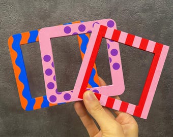 May include: Three square frames with distinct patterns. The first frame features orange and blue wavy lines. The second frame is light pink with purple polka dots. The third frame displays alternating red and light pink vertical stripes.