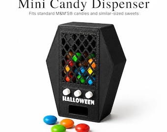 May include: A black coffin-shaped mini candy dispenser with a diamond-patterned grid front, three white knobs, and the word HALLOWEEN printed in white. The text Mini Candy Dispenser and Fits standard M&M'S candies and similar-sized sweets is visible.