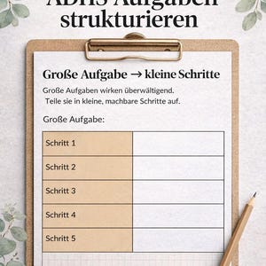 May include: A digital download clipboard with the text "ADHS Aufgaben strukturieren" and "Große Aufgabe → kleine Schritte". The clipboard has a grid for breaking down tasks into smaller steps. A pencil rests on the side.