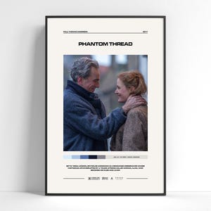 May include: A framed movie poster for Phantom Thread featuring a central photograph of two people facing each other. The poster includes the title, director, year, a color palette bar, a brief synopsis, and production logos on a cream background.