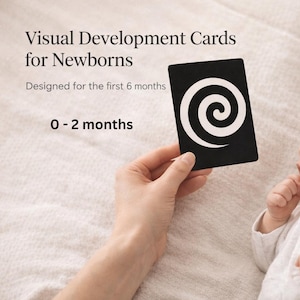 Könnte beinhalten: Eine schwarz-weiße visuelle Entwicklungskarte mit Spiralmuster wird einem Baby gezeigt. Die Karte ist Teil eines Sets für Neugeborene im Alter von 0-2 Monaten. Der Text "Visual Development Cards for Newborns" ist enthalten.