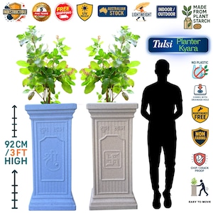 Puede incluir: Dos maceteros cuadrados y altos, uno azul claro y otro beige, cada uno con una planta verde. Los maceteros miden 92 cm de alto y presentan diseños y texto en relieve. La imagen incluye iconos que indican durabilidad y facilidad de movimiento.