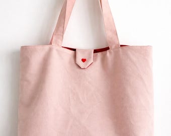 Bolso tote rosa con cierre de broche.