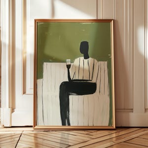 May include: Abstract art print in a gold frame. The artwork depicts a figure seated on a white bench, holding a glass of wine. The figure is wearing a striped shirt and black pants. The background is a solid green color.