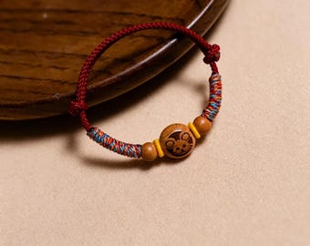 Pulsera de cuerda roja hecha a mano de madera de durazno con doce animales del zodiaco, que simboliza protección, ajustable y de buena suerte, un accesorio de bendición para bebés.