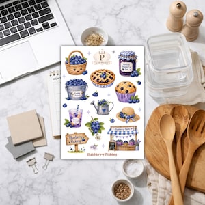 May include: A sheet of stickers with blueberry-themed illustrations. The designs include a basket of blueberries, a pie, a jar of jam, a muffin, a drink, a watering can, a hat, and a blueberry farm stand. The text "Blueberry Picking" is also present.