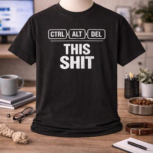 Puede incluir: Camiseta negra con el texto blanco "CTRL ALT DEL THIS SHIT". La camiseta presenta las teclas CTRL, ALT y DEL encima del texto. La camiseta se muestra en un maniquí.