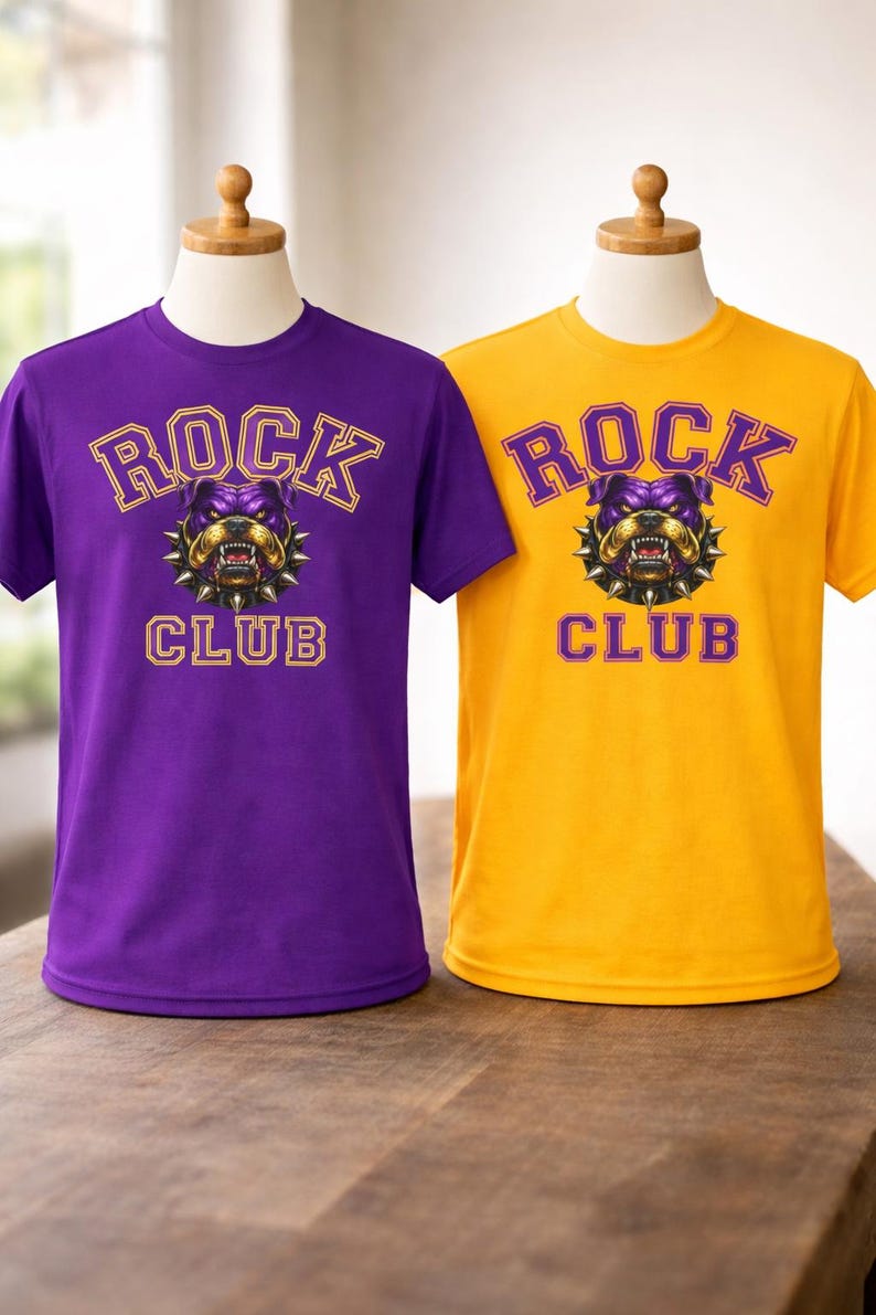 Op de afbeelding: Twee T-shirts, &eacute;&eacute;n paars en &eacute;&eacute;n geel, elk met de tekst "ROCK CLUB" boven en onder een bulldog-afbeelding. De bulldog is paars en goud, met een spijkerhalsband. De shirts worden op mannequins getoond.