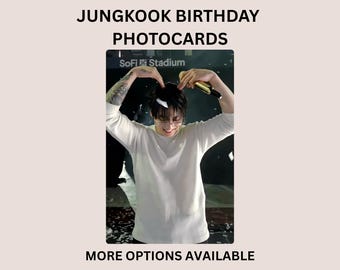 May include: A rectangular Jungkook birthday photocard featuring a person in a white long-sleeve shirt making a heart shape with their hands above their head while holding a gold microphone. The text reads JUNGKOOK BIRTHDAY PHOTOCARDS and MORE OPTIONS AVAILABLE.