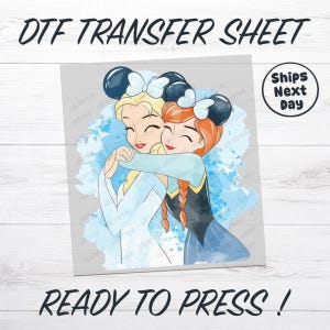 May include: DTF transfer sheet featuring a cartoon illustration of two hugging princesses, one with blonde hair and the other with red hair, both wearing mouse ears. The text "DTF TRANSFER SHEET" and "READY TO PRESS!" are displayed.