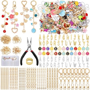 May include: A collection of jewelry-making supplies, including gold-colored chains, keychains, charms, and letter pendants. The image also features a pair of pliers and a gold ring. Various charms include hearts, flowers, and other decorative elements.