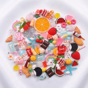 May include: A collection of miniature resin charms featuring various food items like orange slices, watermelon, strawberries, chocolate bars, and cookies, alongside rainbows, stars, cartoon characters, bottles, and starfish in vibrant colors.