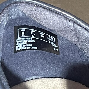 May include: Close-up of the inside of a dark blue shoe. A black label displays size information: UK 5, US 7&frac12; M, EU 38, and CM 23.5. The label also includes the text "WOMENS/FEMMES" and "MADE IN CHINA / FABRIQUE EN CHINE".