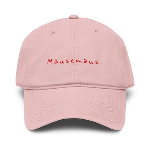 Könnte beinhalten: Hellrosa Baseballkappe mit gebogenem Schirm. Auf der Kappe ist der rote Text "Mausemaus" aufgestickt. Die Kappe hat ein sechsteiliges Design mit einem Knopf oben.