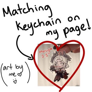 May include: An acrylic keychain featuring a chibi-style character with white hair, wearing a dark outfit and holding a small skull. The text on the keychain reads Mercy 2.5 inches. The image includes handwritten text stating Matching Keychain on my page and art by me.