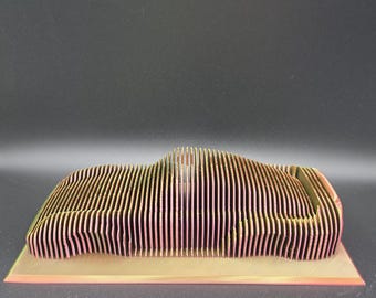 Impresión 3D de un coche deportivo en capas: escultura iridiscente de arcoíris, arte automovilístico.