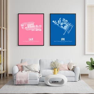May include: Two framed prints of airport diagrams. One print has a pink background with a white diagram of LAX, the Los Angeles International Airport. The other print has a blue background with a white diagram of JFK, John F. Kennedy International Airport.