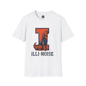 Può includere: T-shirt bianca con un cane dei cartoni animati che indossa una maglia blu e arancione, seduto davanti a una grande "I" arancione. Il testo "ILLI-NOISE" è stampato sotto il cane in blu navy.