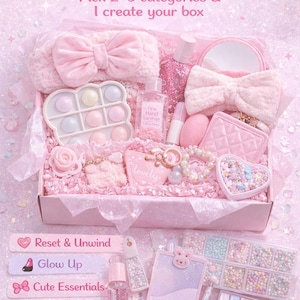May include: A pink gift box filled with beauty and self-care items. The box includes a headband, a pop-it toy, hand sanitizer, a mirror, a bracelet, and other accessories. Text on the image reads "Build Your Own Box".