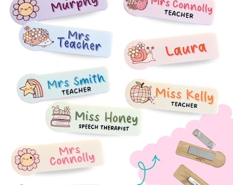 May include: A selection of pastel-colored name badges with different names and illustrations, including a flower, strawberry, and snail. The badges feature names like "Ms Murphy" and "Mrs Connolly." The text "32 patterns to choose from" is also visible.