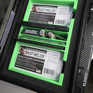 Puede incluir: Un estuche negro con interior verde, que contiene suministros de soldadura. El estuche contiene dos paquetes de lentes de protecci&oacute;n "BEST WELDS", junto con otras herramientas. Los paquetes tienen texto en ingl&eacute;s, franc&eacute;s y espa&ntilde;ol. El estuche est&aacute; etiquetado "ELEGCO".