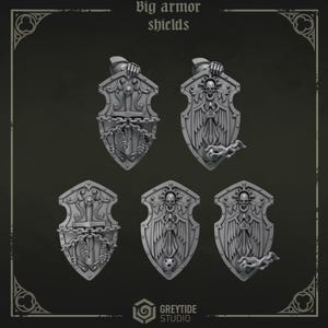 May include: Five grey miniature armor shields featuring intricate relief designs including skulls, swords, wings, chains, and feathers. The top text reads Big armor shields and the bottom logo reads GREYTIDE STUDIO. These are detailed gaming accessories.