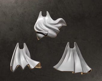 May include: Three miniature grey cloaks with sculpted folds and flowing designs. The top center cloak is dynamic, while the bottom two display different draping styles. The text CLOAKS appears at the top and GREYTIDE STUDIO at the bottom.