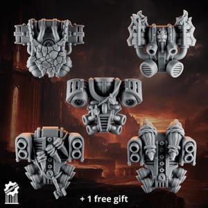 May include: Five grey resin miniature jetpacks for tabletop gaming figures. The designs include a stone-textured pack, a flame-adorned pack, a central pack with straps, and two packs featuring wrapped bone or weapon details. Each piece is unpainted and detailed.