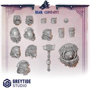 Op de afbeelding: Een verzameling lichtgrijze miniatuurharscomponenten, waaronder schouderstukken met berenthema, helmen, een hamer en een schild. De tekst BEAR COMPANY en GREYTIDE STUDIO is zichtbaar. Deze gedetailleerde onderdelen zijn voor tabletop-gaming.