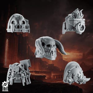 Puede incluir: Un conjunto de cinco componentes de juego en miniatura de resina gris que incluye cuatro hombreras distintas con detalles esculpidos como cadenas, llamas y calaveras, y un casco central con una amplia sonrisa dentada y orejas largas.