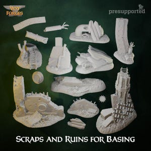 Puede incluir: Una colección de piezas de terreno en miniatura blancas impresas en 3D, que incluyen ruinas de edificios, tuberías y otros elementos industriales. El texto "SCRAPS AND RUINS FOR BASING" se muestra en la parte inferior de la imagen. El logotipo de Voy Forges está en la esquina superior izquierda.