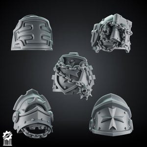 May include: A set of five grey resin miniature shoulder pads for tabletop gaming figures. The designs include embossed cross motifs, a skull with a book wrapped in chains, a shield with a cross and chain, and a helmet-style pad with chain details.