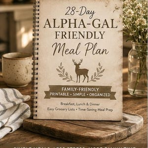Puede incluir: Un libro de plan de comidas con encuadernación en espiral titulado 28-Day ALPHA-GAL FRIENDLY Meal Plan. La portada presenta una ilustración de un ciervo, una pancarta con el texto FAMILY-FRIENDLY PRINTABLE - SIMPLE - ORGANIZED y el texto Breakfast, Lunch & Dinner.