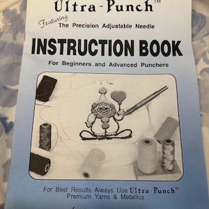 May include: An instruction book for Ultra-Punch needlework, featuring a clown design. The cover is light blue with the text "Ultra-Punch" and "Instruction Book". Includes the text "For Beginners and Advanced Punchers". Printed in the U.S.A.