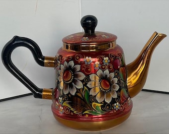 Tetera rusa antigua Khokhloma de metal pintada a mano con motivos florales en rojo y dorado, arte popular.