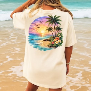 May include: Off-white t-shirt with a colourful beach design on the back. The illustration shows a sunset, palm trees, ocean waves, and flowers. The shirt has short sleeves and a loose fit, suitable for everyday wear.