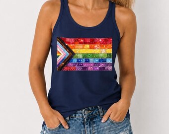 May include: A navy blue tank top featuring a rectangular graphic print of a pride flag composed of horizontal stripes in red, orange, yellow, green, blue, and purple, with a chevron pattern on the left side in black, brown, and white.