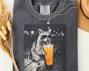 Maglietta Comfort Colors con procione che beve succo d'arancia, maglietta retrò preistorica, regalo per amanti degli animali, maglietta divertente con meme di animali, maglietta con procione al caffè
