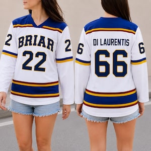 May include: A white hockey jersey featuring blue and yellow stripes on the sleeves and hem. The front displays the text BRIAR and the number 22 in dark blue. The back shows the name DI LAURENTIS and the number 66 in dark blue lettering.