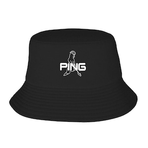 May include: Black bucket hat with the white text "PING" and a graphic of a golfer. The hat has a wide brim and a classic, casual style. Perfect for sun protection or a fashion statement.