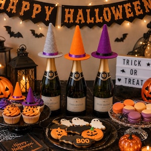 May include: A Halloween-themed arrangement with champagne bottles topped with miniature witch hats in grey, orange, and purple. The display includes cupcakes, biscuits, and macarons, all decorated with Halloween motifs, and a sign saying "Trick or Treat."
