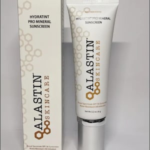May include: A white tube and box of Alastin Skincare Hydratint Pro Mineral Sunscreen. The tube has a silver cap and the box has the product name and brand logo in brown. The product is broad spectrum SPF 36 and water resistant.