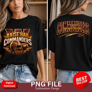 May include: A black t-shirt featuring a graphic design on the front and back. The front displays a football helmet, a football, and the text "RAISE HAIL COMMANDERS". The back features the word "COMMANDERS" in large, bold, arched lettering.