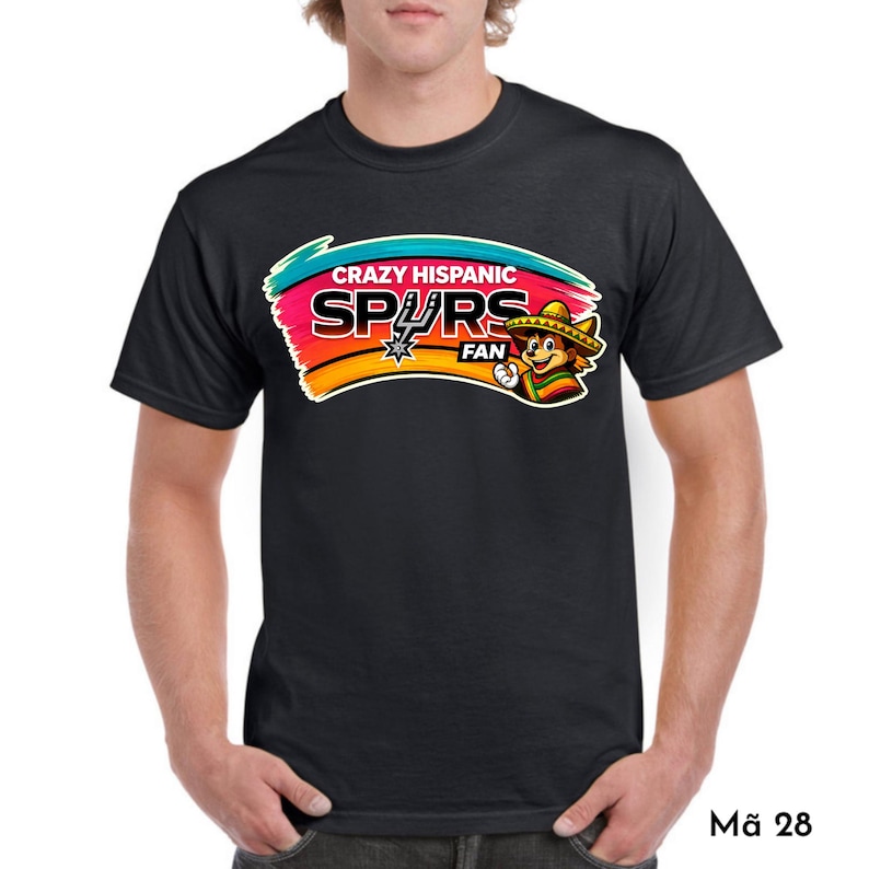 Op de afbeelding: Zwart T-shirt met een kleurrijke opdruk van "Crazy Hispanic Spurs Fan". Het ontwerp toont een cartoonfiguur met een sombrero en het Spurs-logo. Het T-shirt heeft een ronde hals.