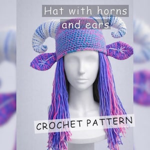 以下が含まれることがあります： 青、紫、白の糸を使った、角と耳が付いたかぎ針編みの帽子。帽子には、紫とピンクの色合いの長い髪が流れています。「Hat with horns and ears」と「CROCHET PATTERN」の文字が見えます。